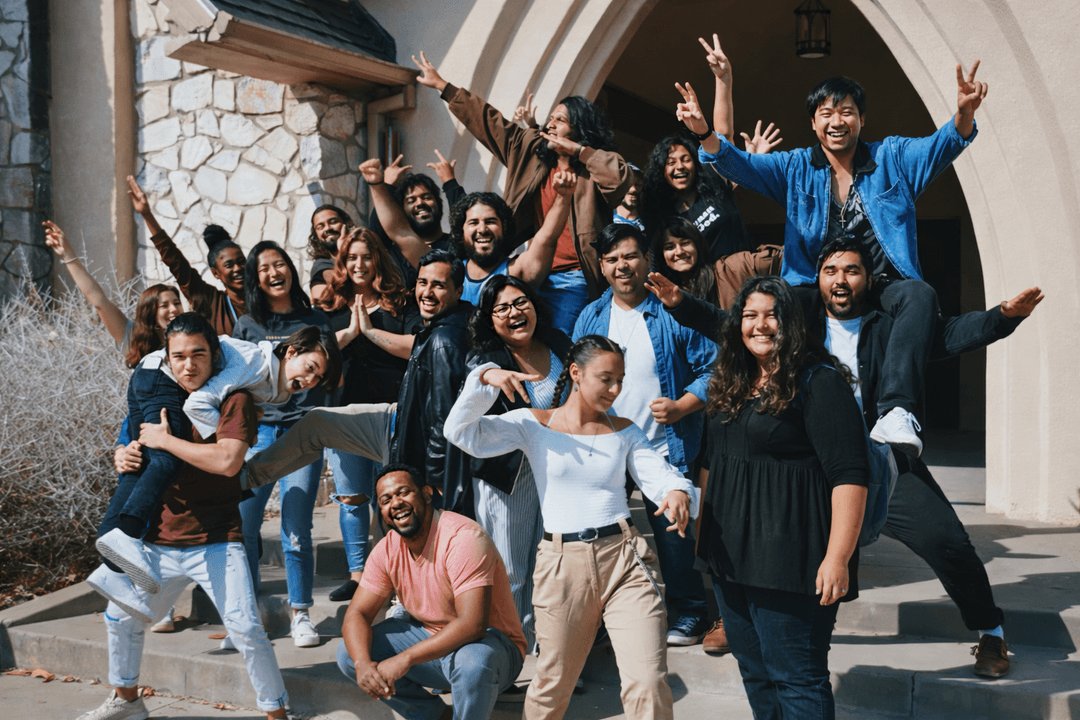 A group of young people celebrating together on stone steps